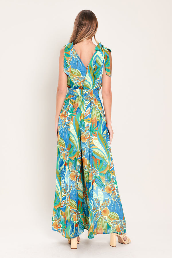 Woman wearing a blue multicolored patterned woven jumpsuit featuring V neckline, shoulder ties, smocked waistband and wide leg | Flying Tomato