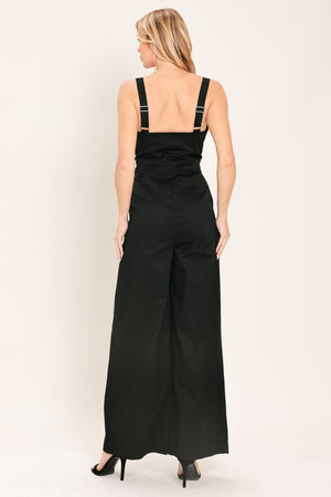 Woman wearing a black wide leg jumpsuit with buttons | Flying Tomato