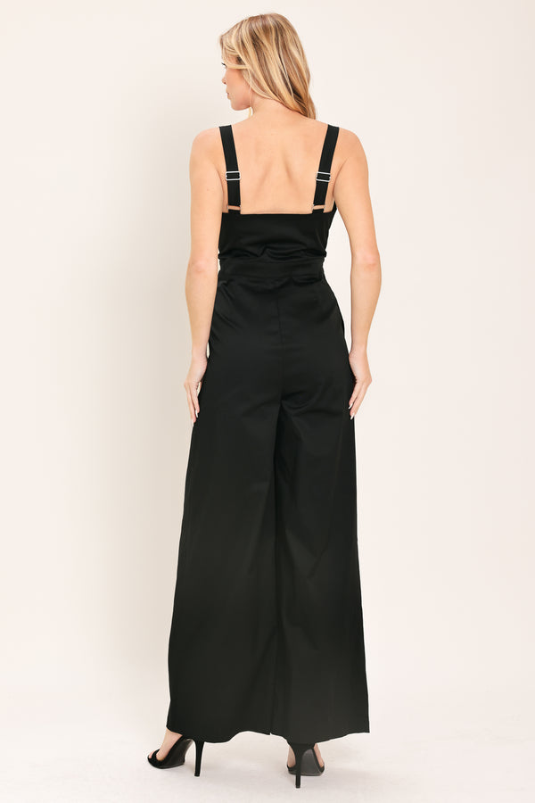 Woman wearing a black wide leg jumpsuit with buttons | Flying Tomato