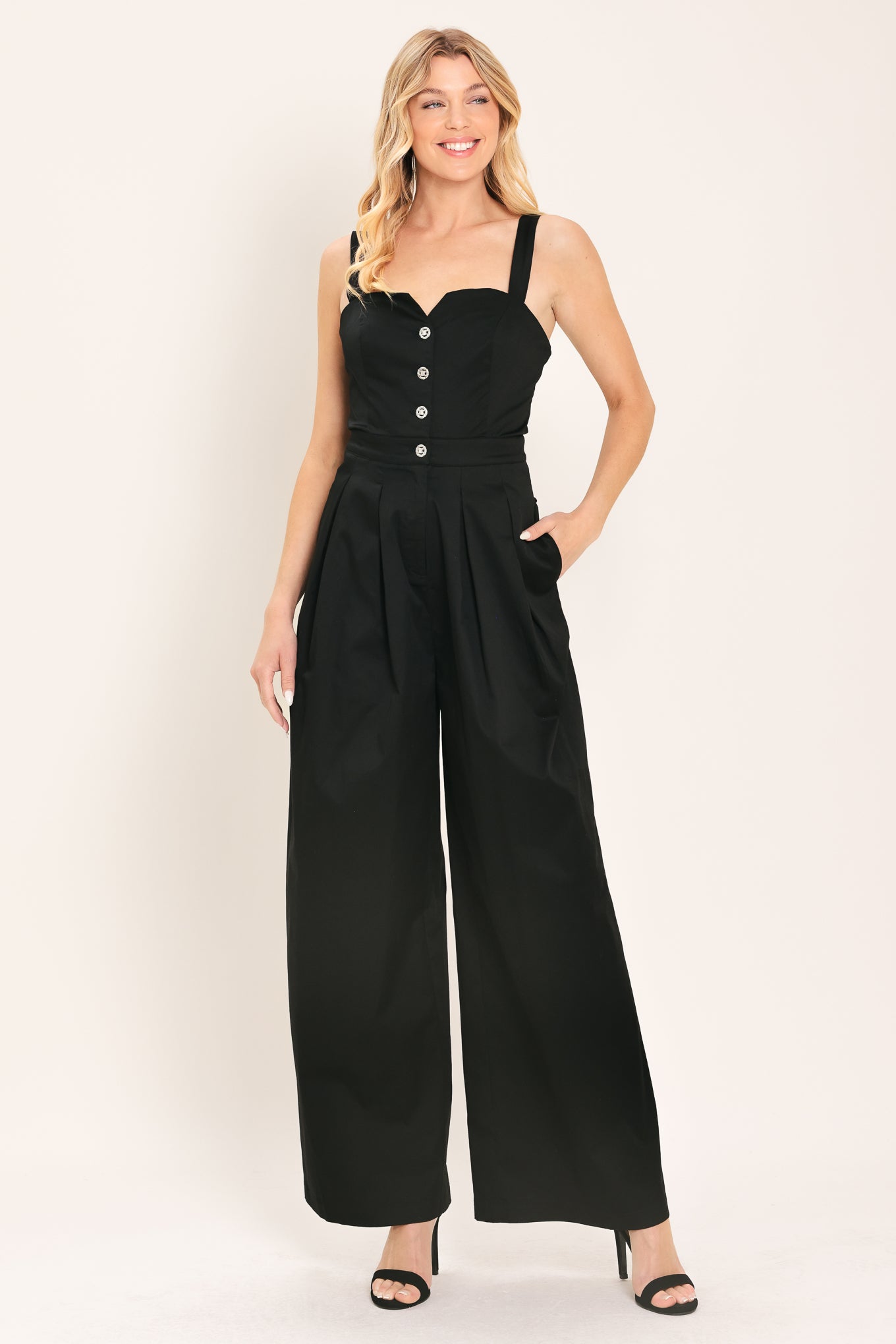 Woman wearing a black wide leg jumpsuit with buttons | Flying Tomato