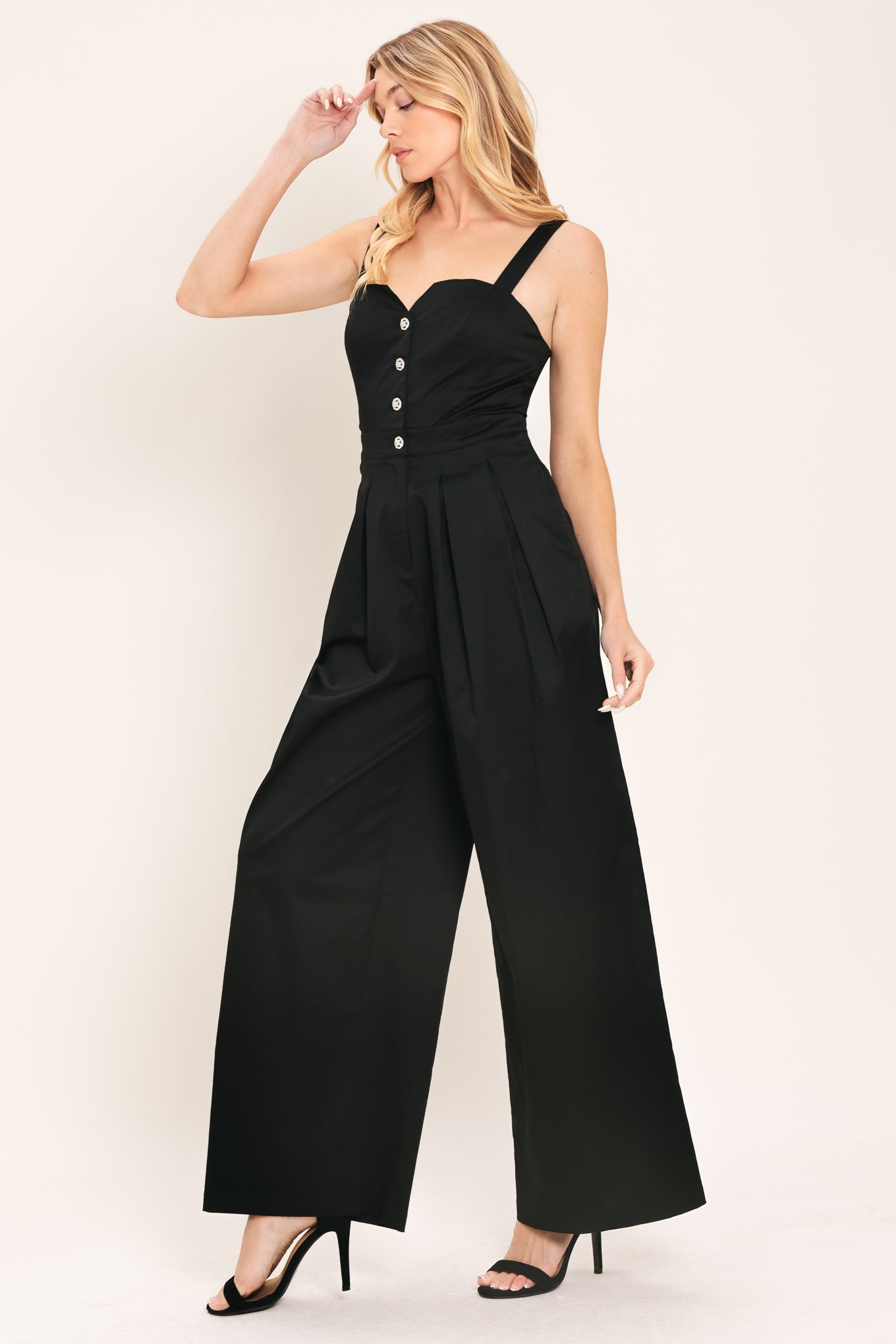 Woman wearing a black wide leg jumpsuit with buttons | Flying Tomato