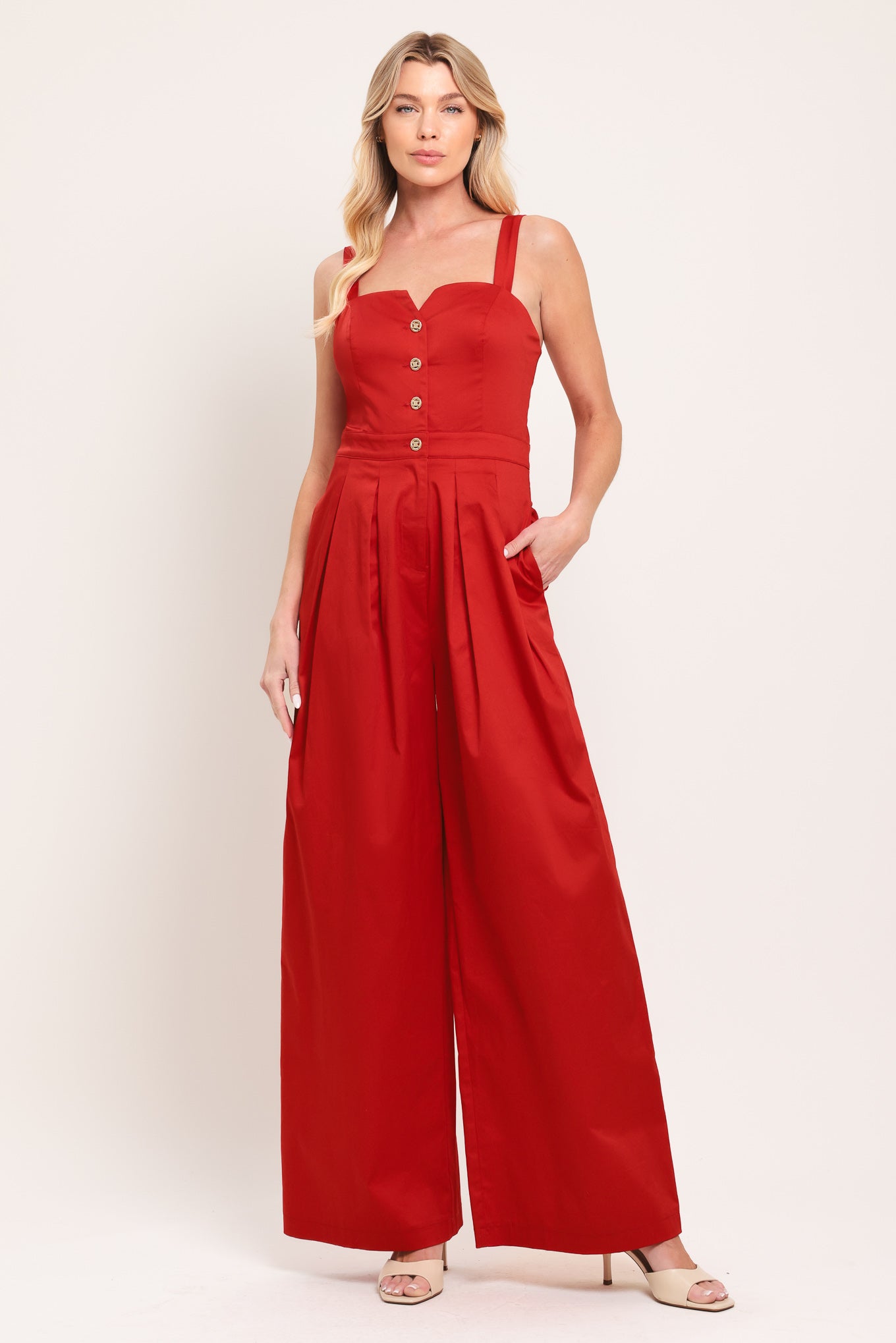 Woman wearing a red wide leg jumpsuit with buttons | Flying Tomato