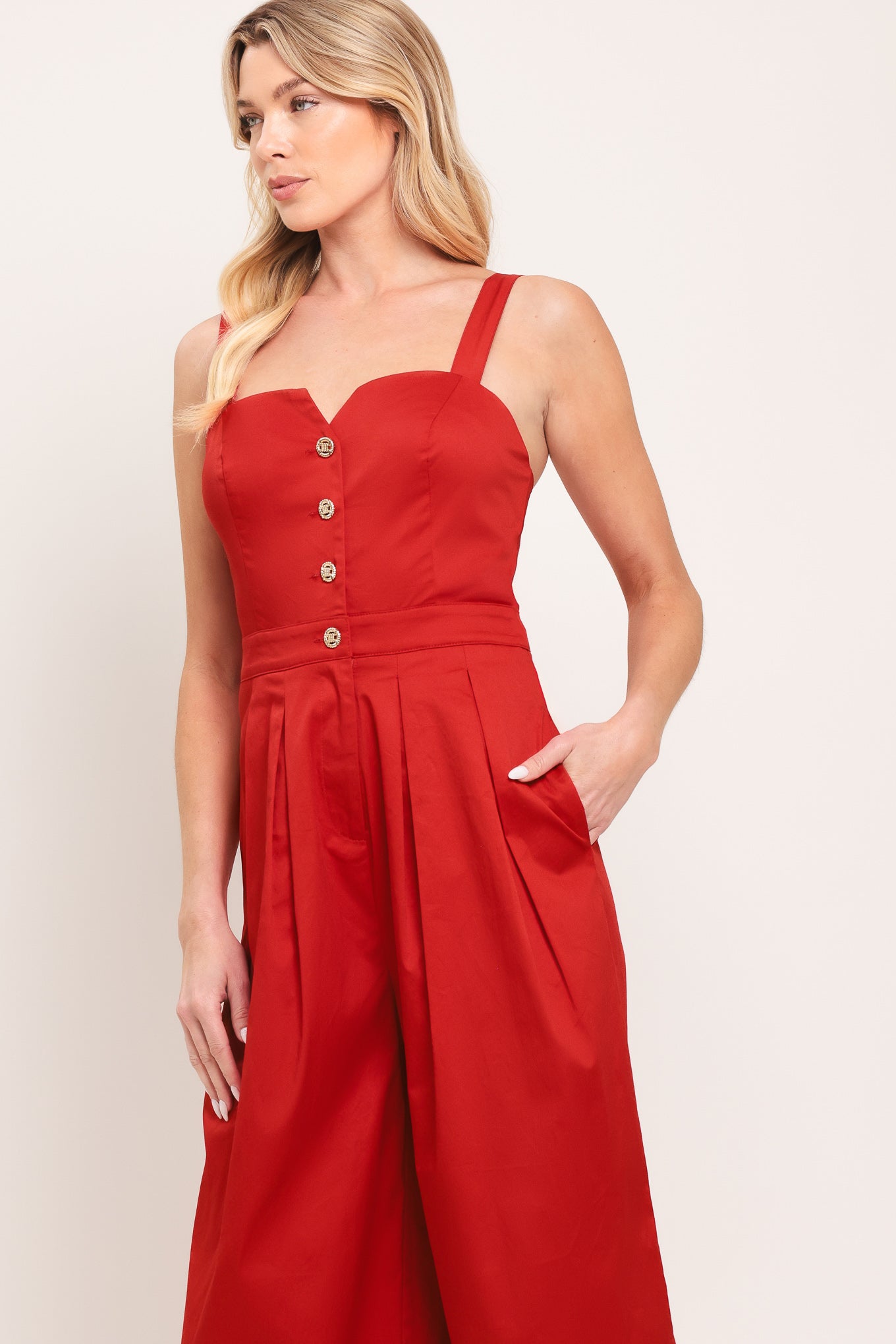 Woman wearing a red wide leg jumpsuit with buttons | Flying Tomato