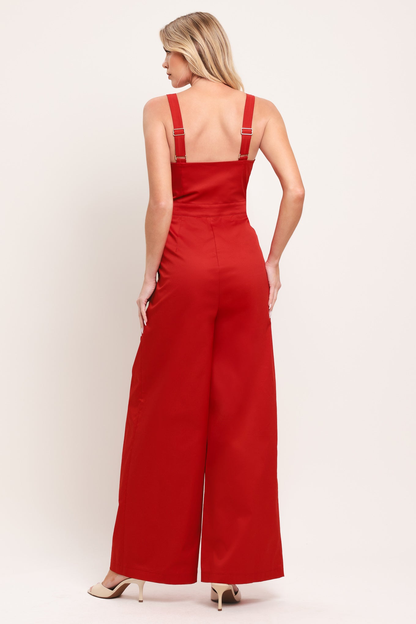 Woman wearing a red wide leg jumpsuit with buttons | Flying Tomato