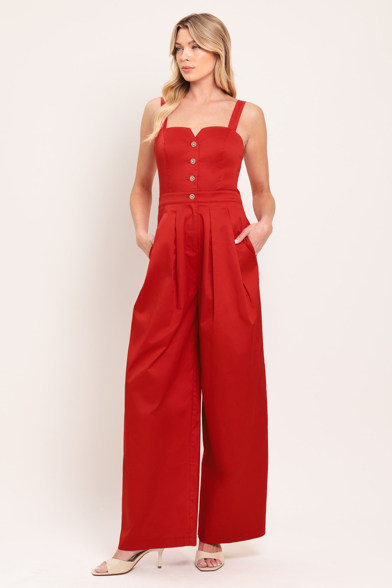 Woman wearing a red wide leg jumpsuit with buttons | Flying Tomato