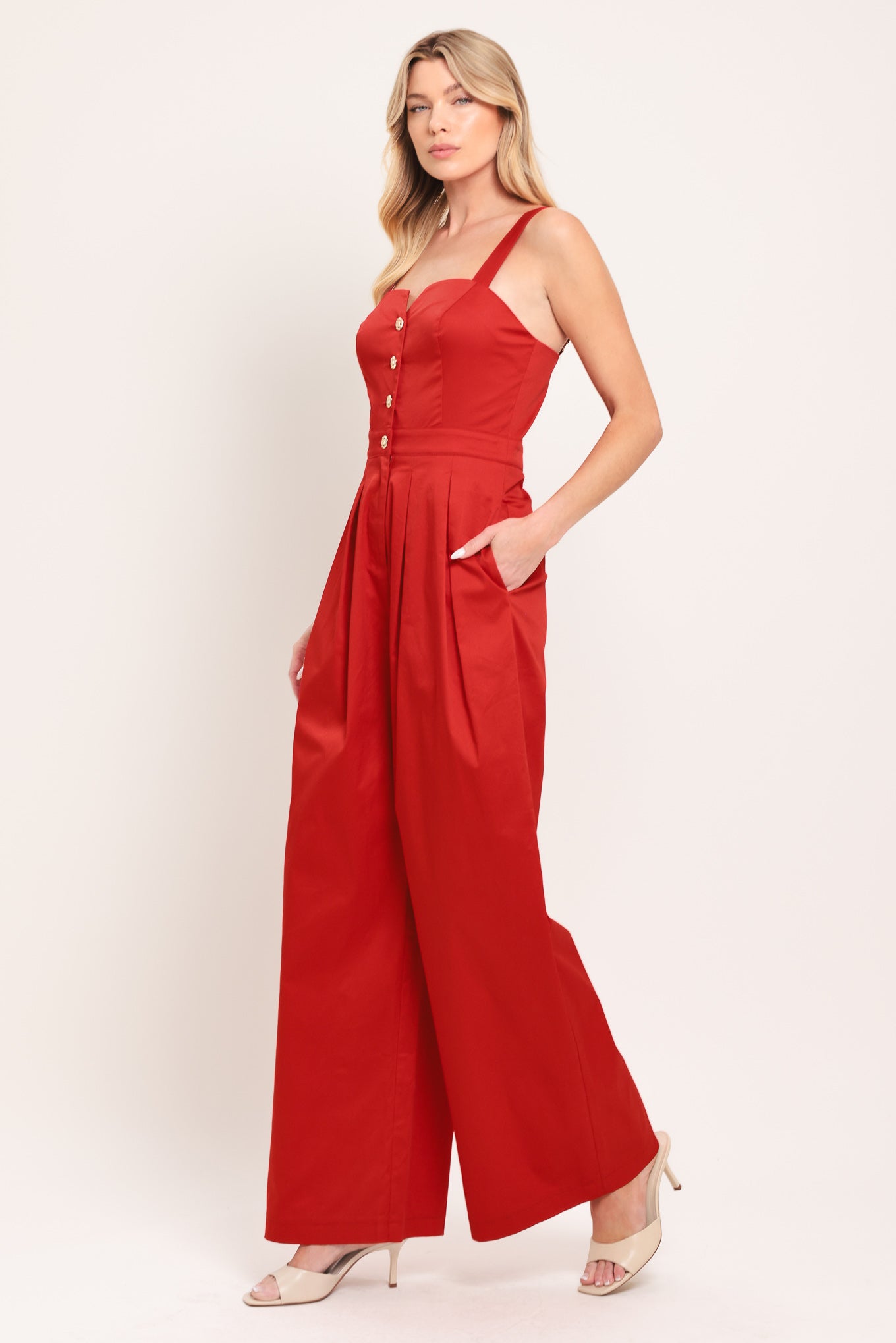 Woman wearing a red wide leg jumpsuit with buttons | Flying Tomato