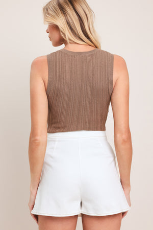 Woman wearing a white denim skort featuring front closure and side bow shaped pocket | Flying Tomato