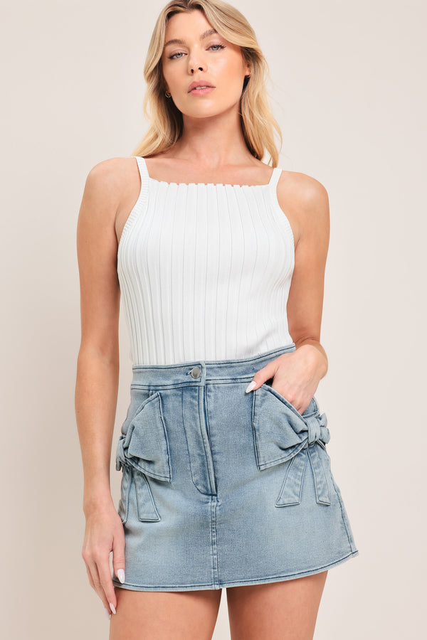 Woman wearing a light blue denim denim skort with front closure and bow pockets | Flying Tomato