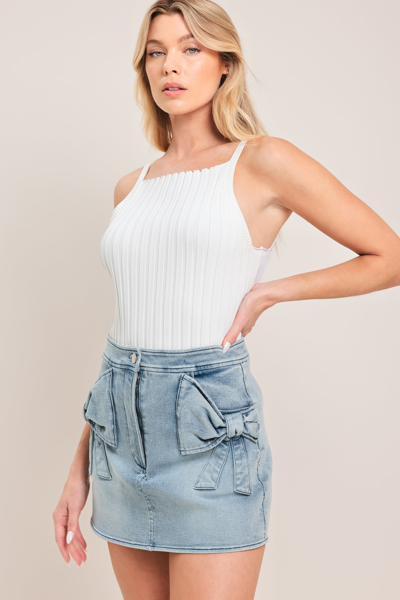 Woman wearing a light blue denim denim skort with front closure and bow pockets | Flying Tomato