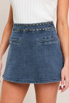 Woman wearing a blue denim skort with studded eyelet waistband denim skort | Flying Tomato