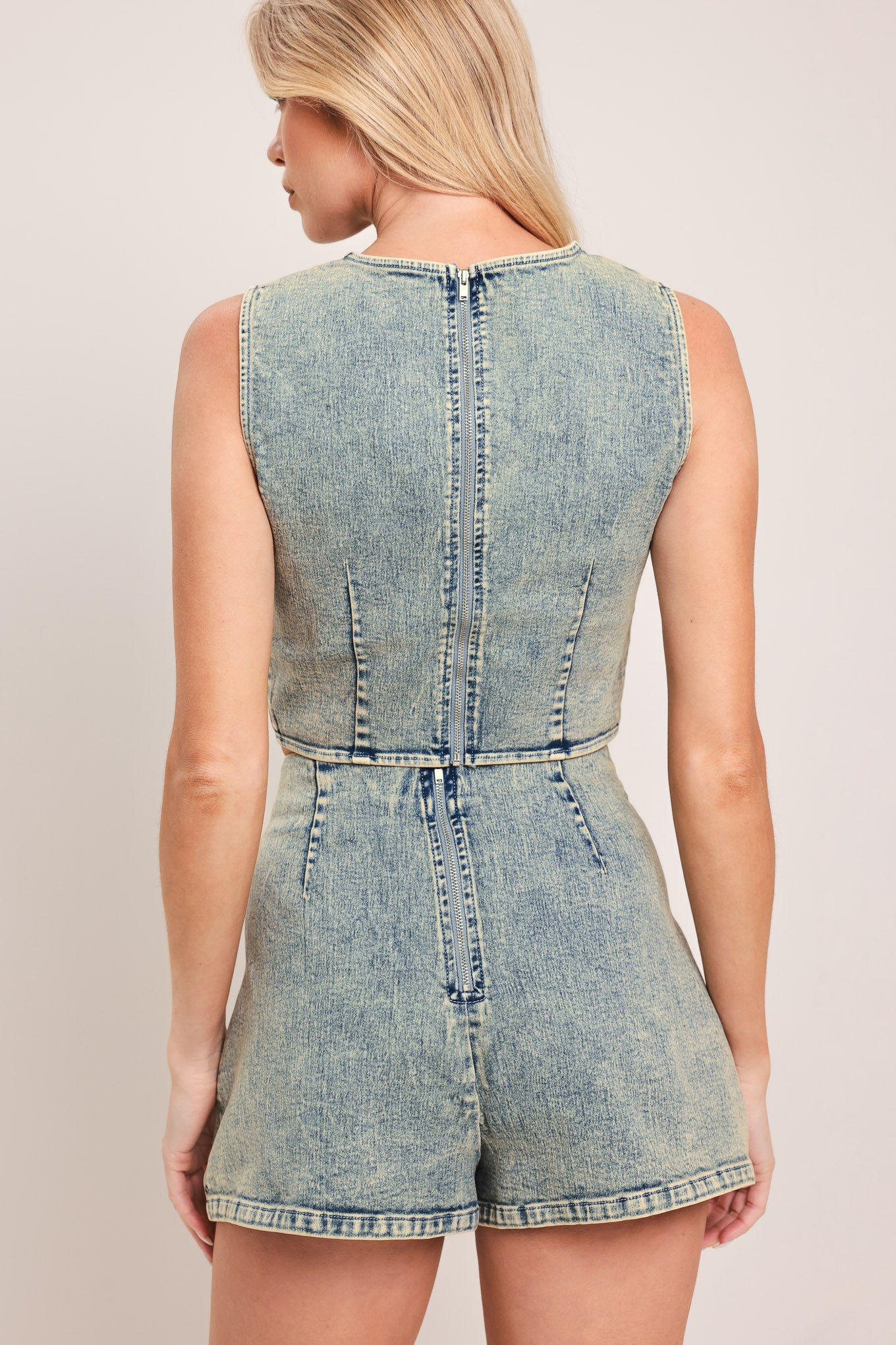 Woman wearing a denim skort featuring scallop edge with button and back zipper closure | Flying Tomato