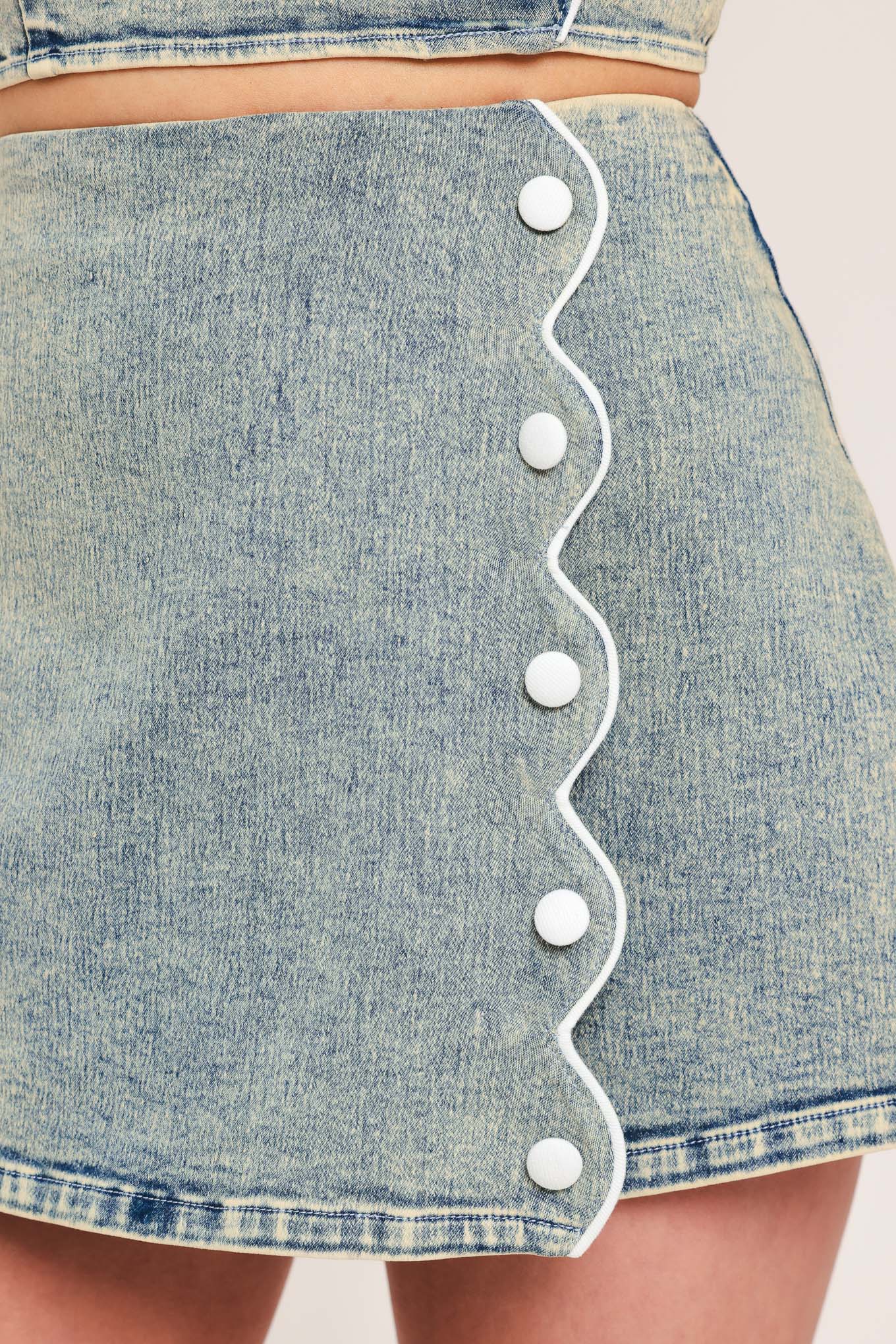 Woman wearing a denim skort featuring scallop edge with button and back zipper closure | Flying Tomato