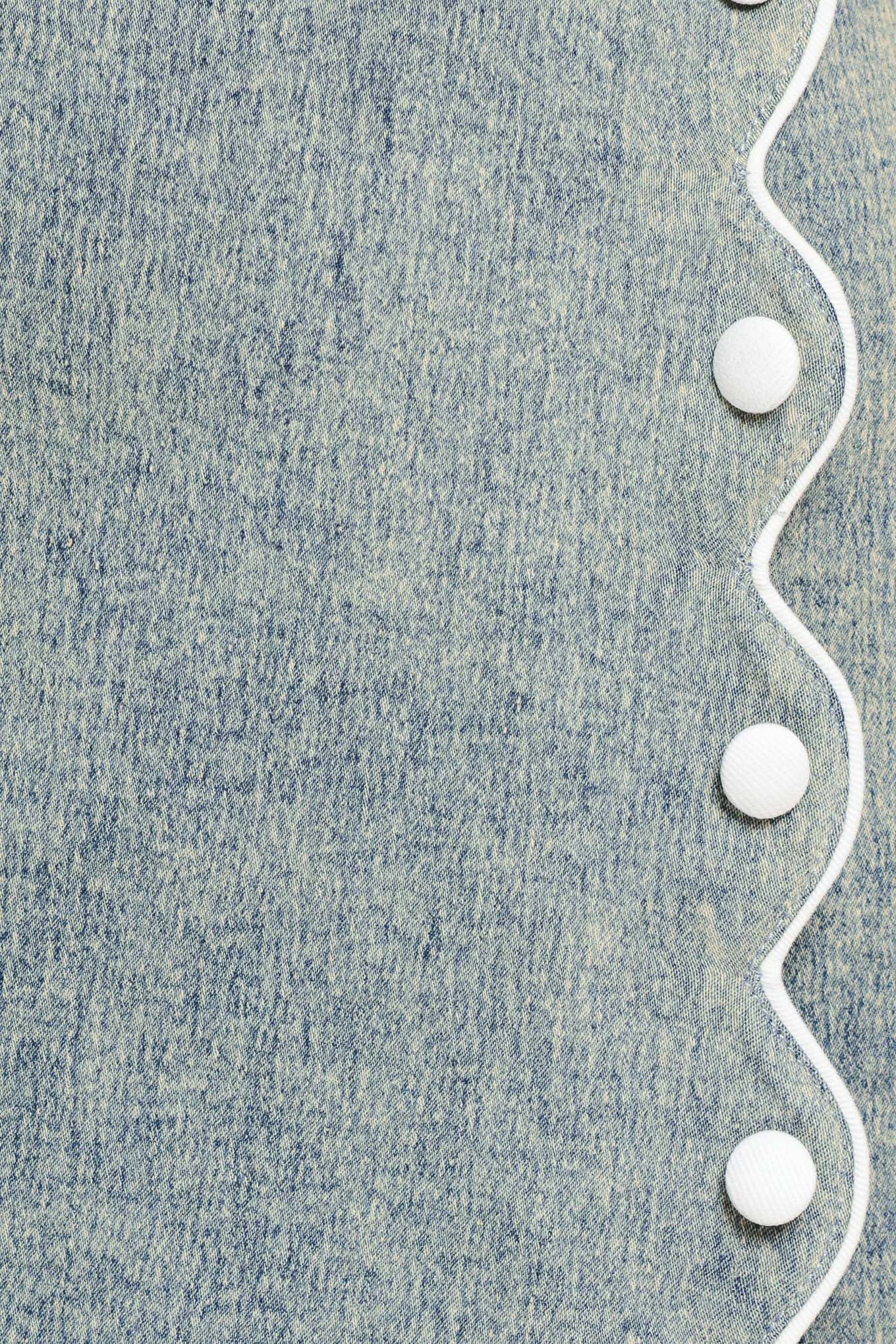 Close-up of denim fabric with a white scallop details and buttons | Flying Tomato