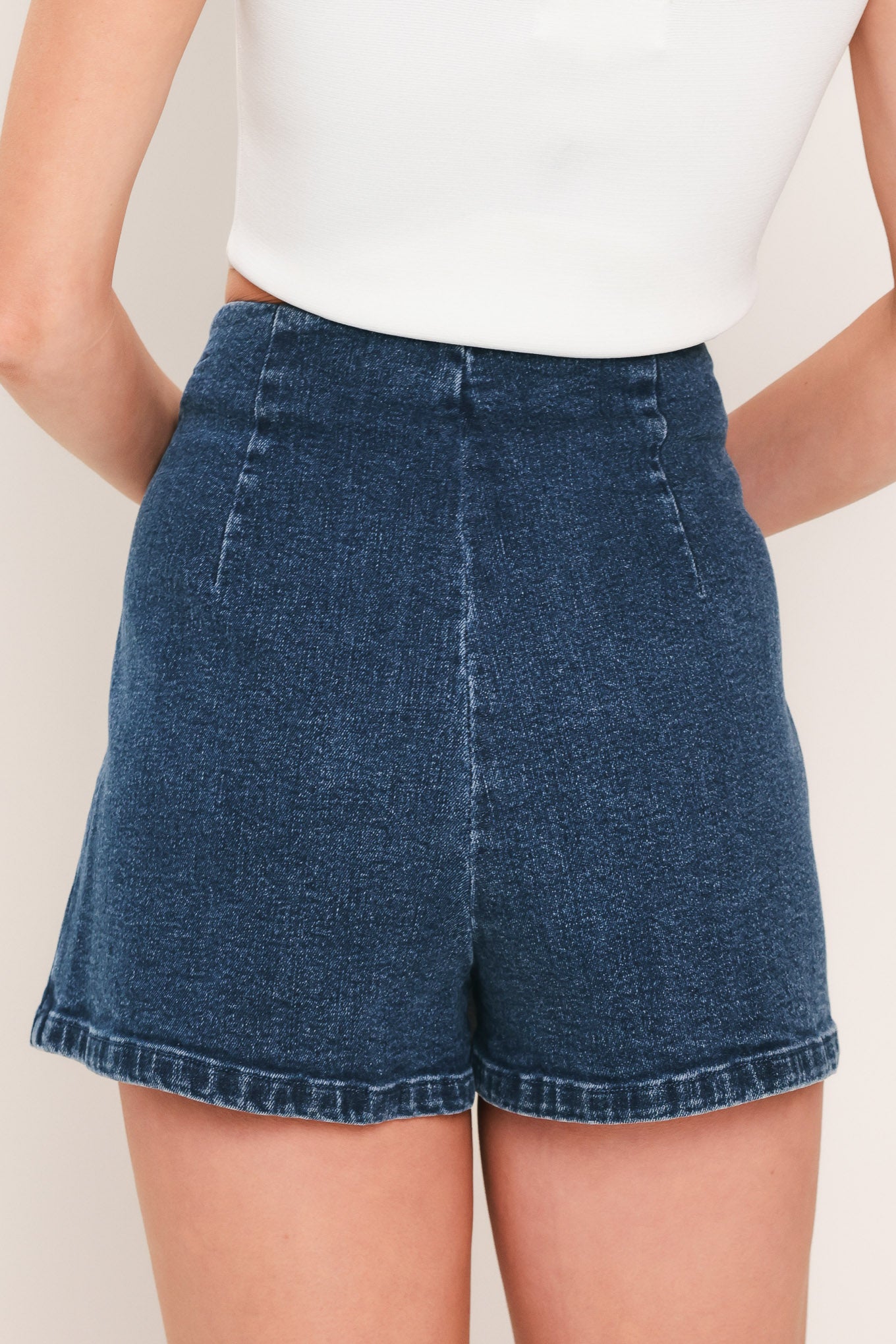 Woman wearing a denim skort featuring side ties and zipper closure | Flying Tomato