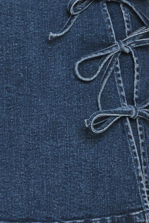 Close-up of a blue denim fabric with a tied bows | Flying Tomato