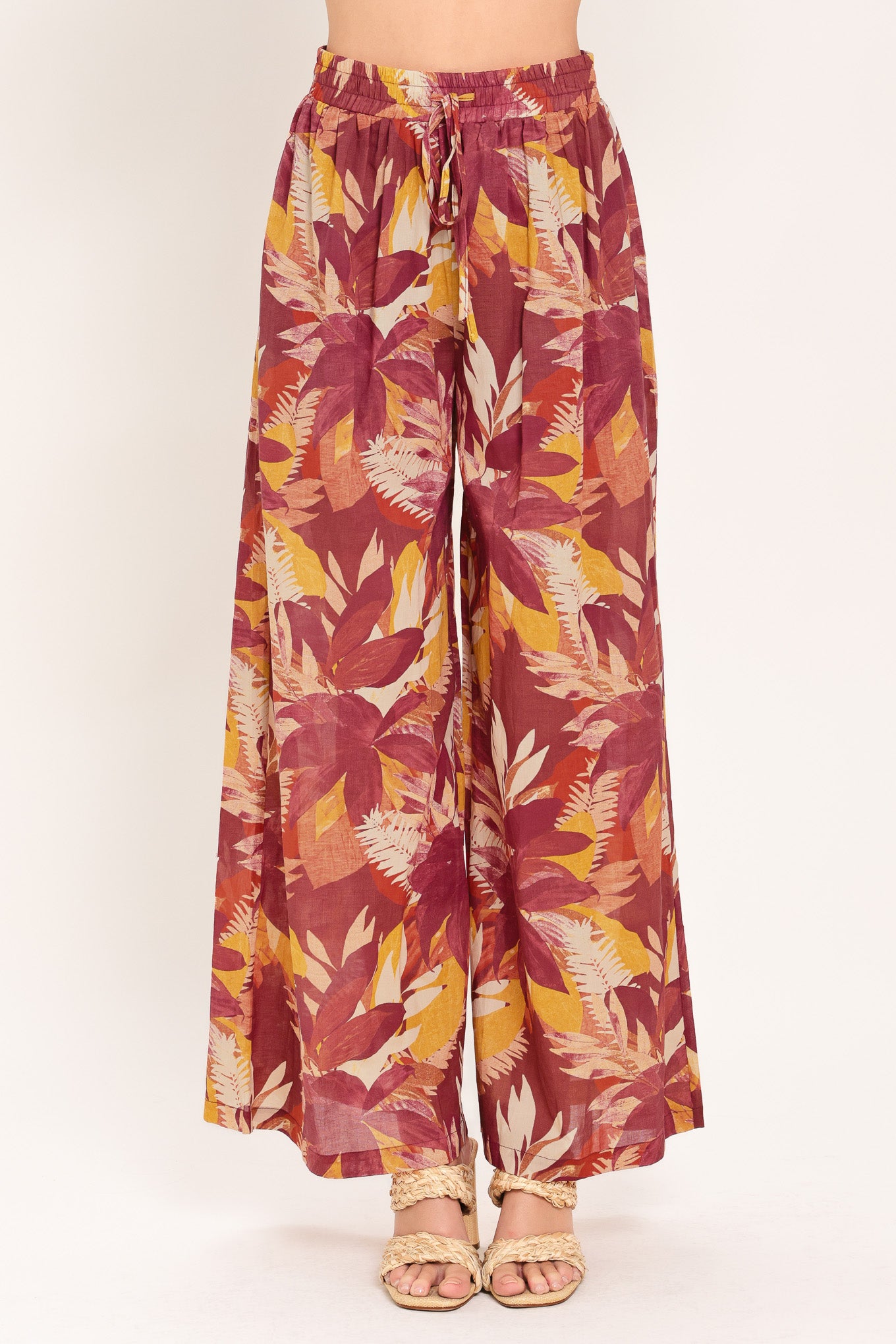 Woman wearing burgundy floral patterned wide leg pants with elastic waist and tie | Flying Tomato