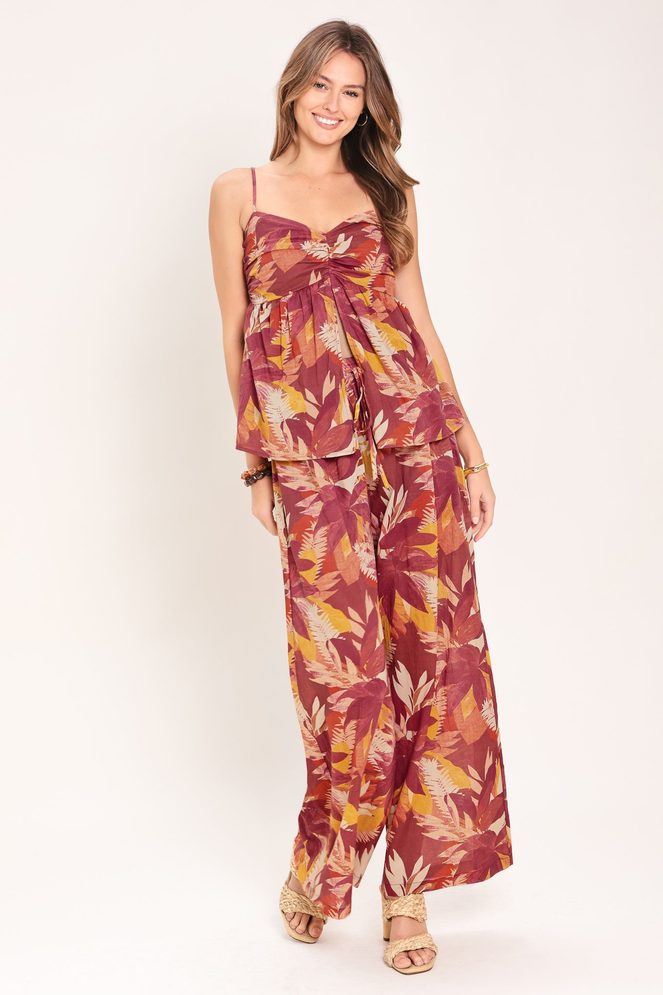 Woman wearing burgundy floral patterned wide leg pants with elastic waist and tie | Flying Tomato