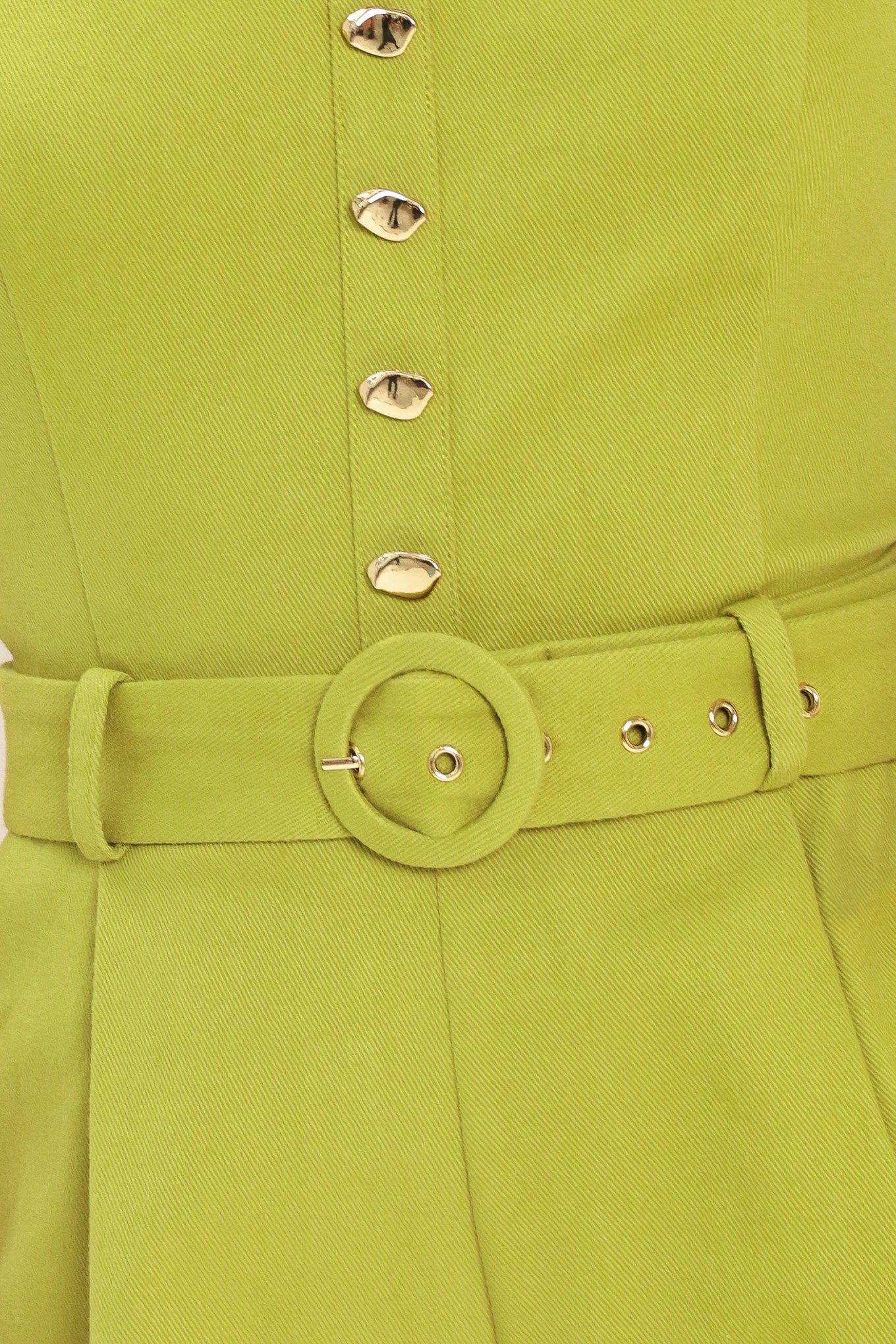 Woman wearing a green romper with buttons and a belt | Flying Tomato