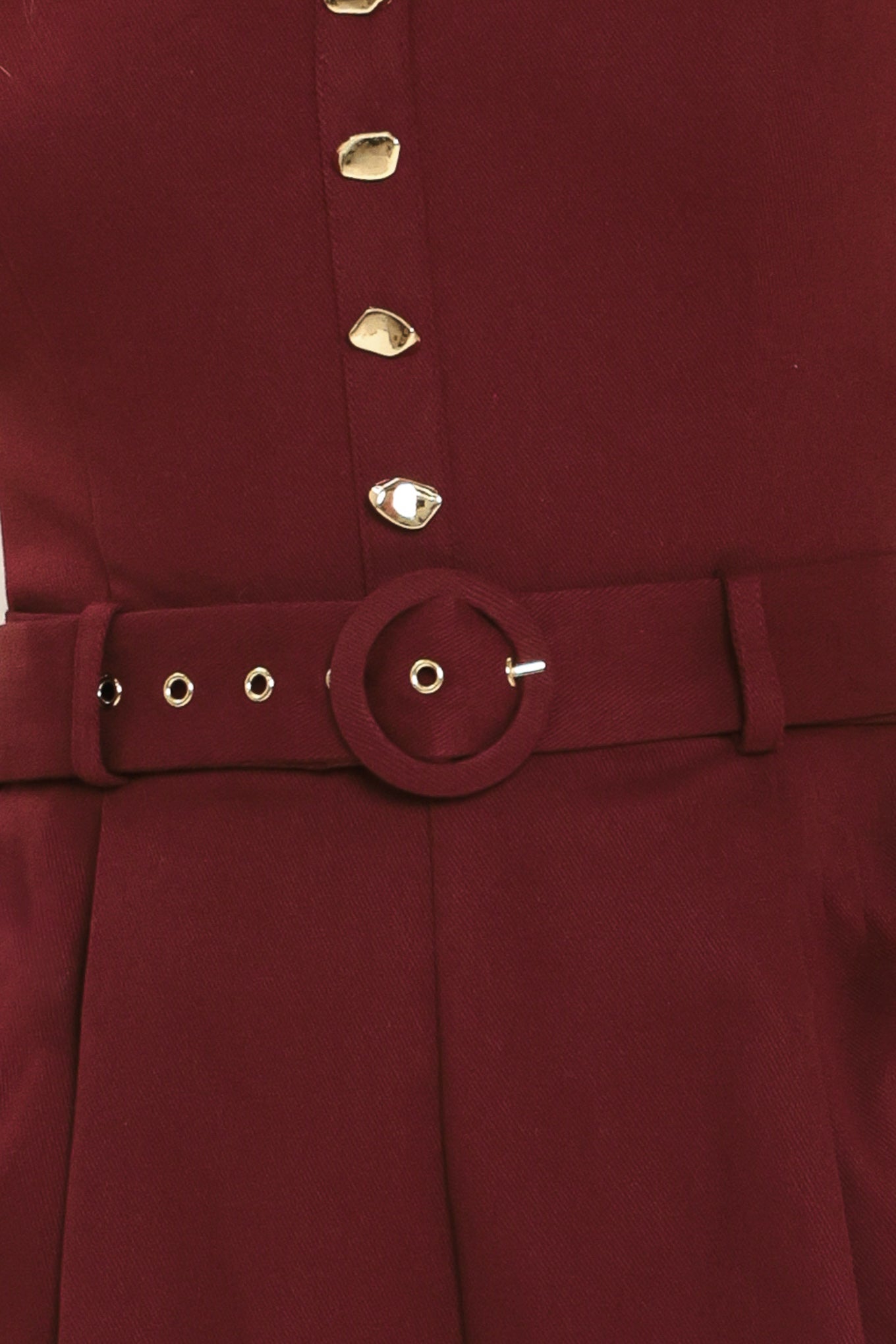 Woman wearing a burgundy romper with buttons and a belt | Flying Tomato