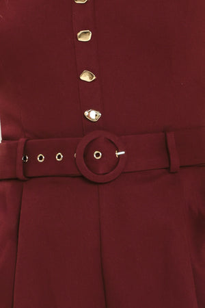 Woman wearing a burgundy romper with buttons and a belt | Flying Tomato