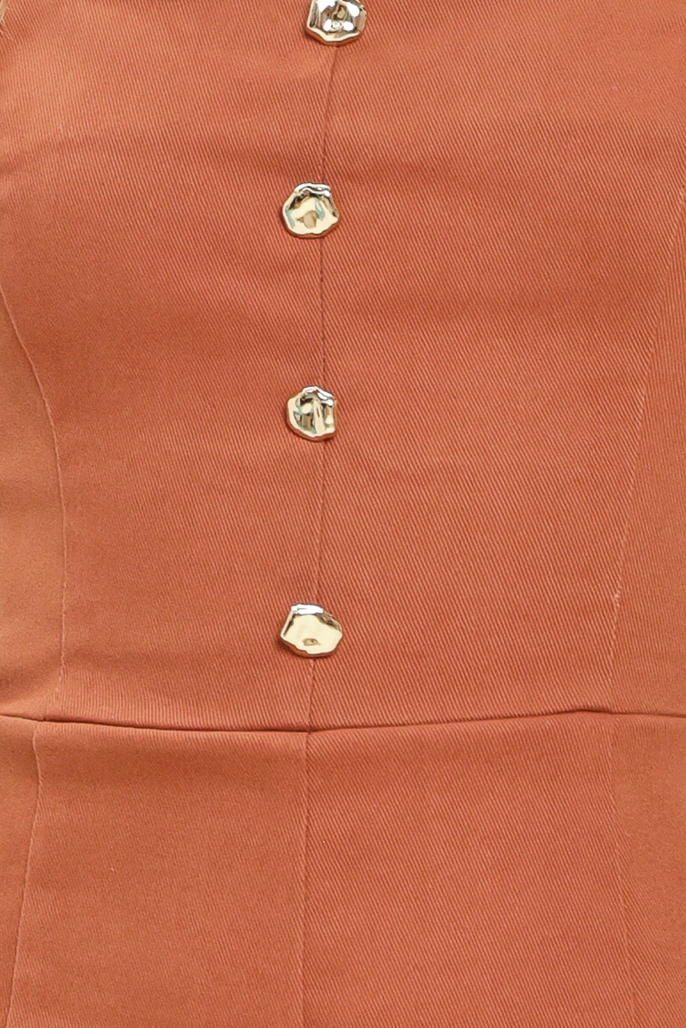 Close up of a rust-colored romper with button details | Flying Tomato