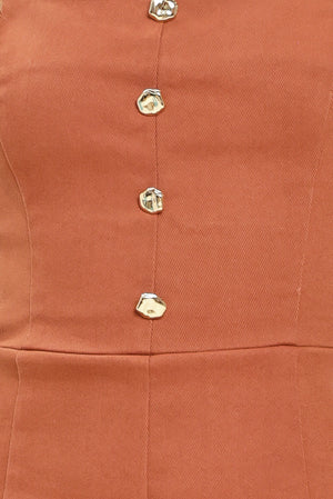 Close up of a rust-colored romper with button details | Flying Tomato