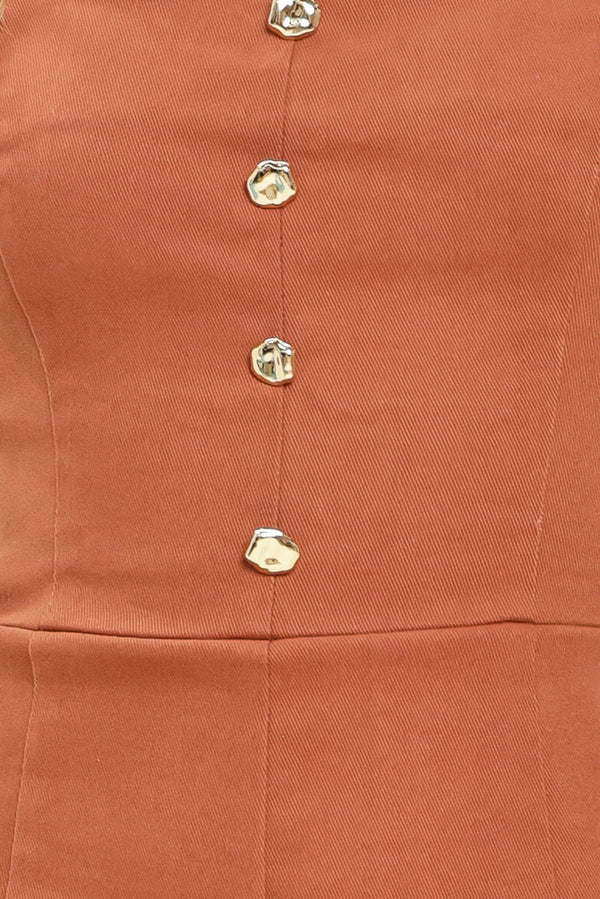 Close up of a rust-colored romper with button details | Flying Tomato