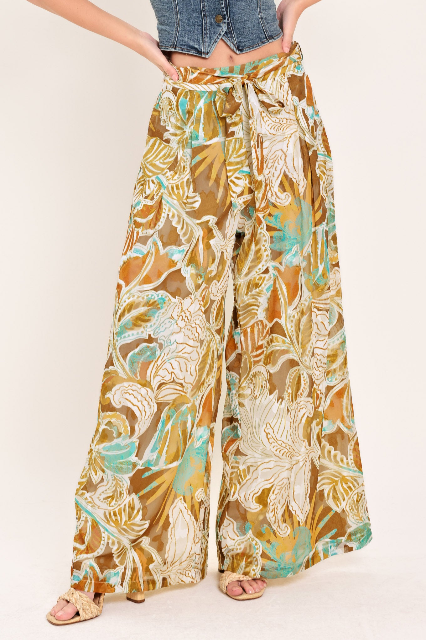 Woman wearing tropical brown, teal, and yellow patterned wide-leg pants | Flying Tomato