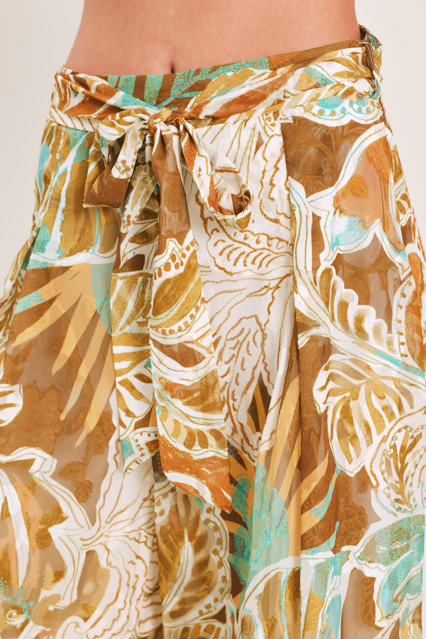 Woman wearing tropical brown, teal, and yellow patterned wide-leg pants | Flying Tomato
