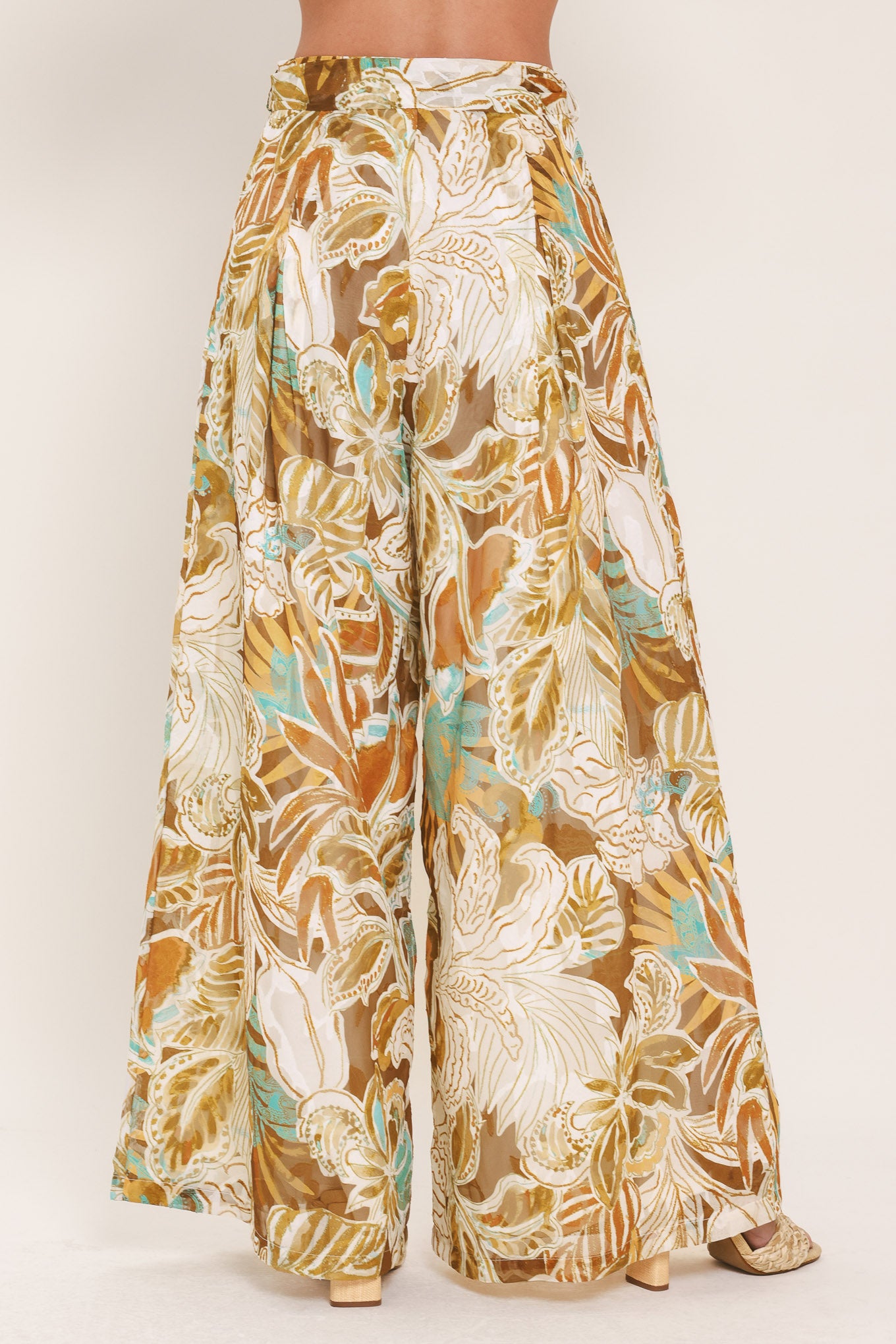 Woman wearing tropical brown, teal, and yellow patterned wide-leg pants | Flying Tomato