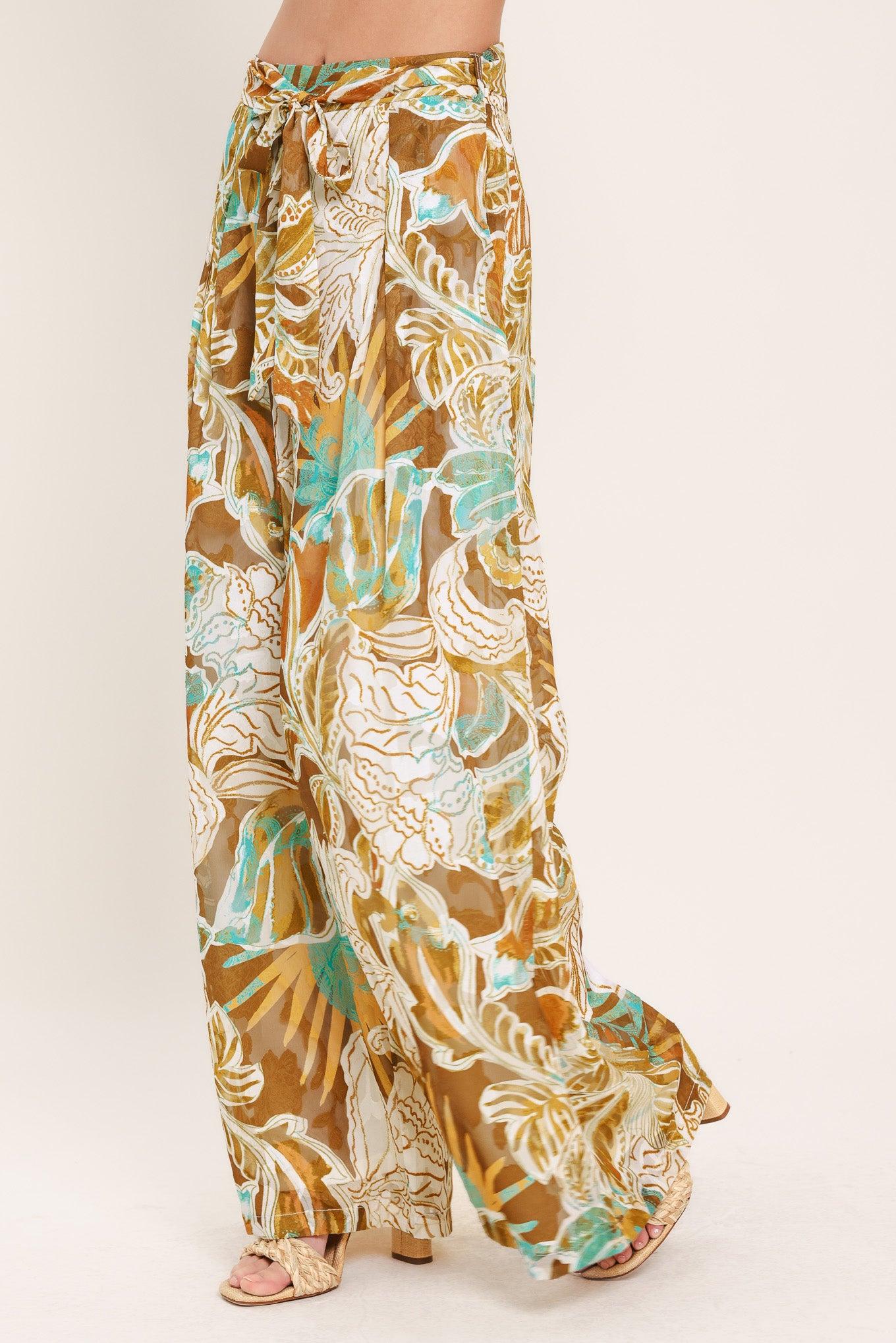 Woman wearing tropical brown, teal, and yellow patterned wide-leg pants | Flying Tomato