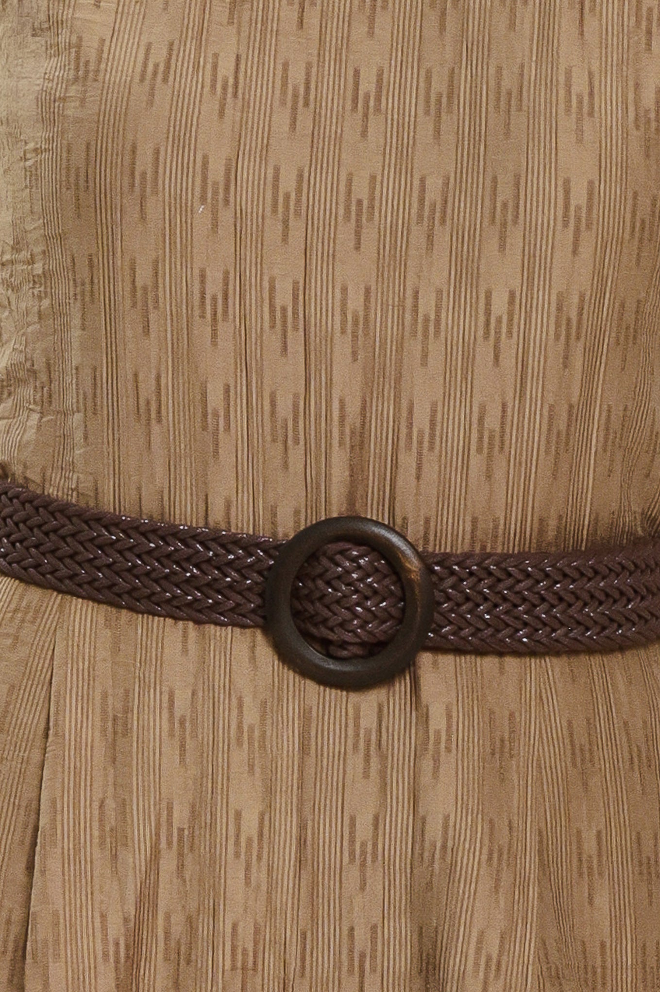 A woman modeling a sleeveless, high-neck, wide-leg jumpsuit in a textured brown fabric with a dark brown belt | Flying Tomato