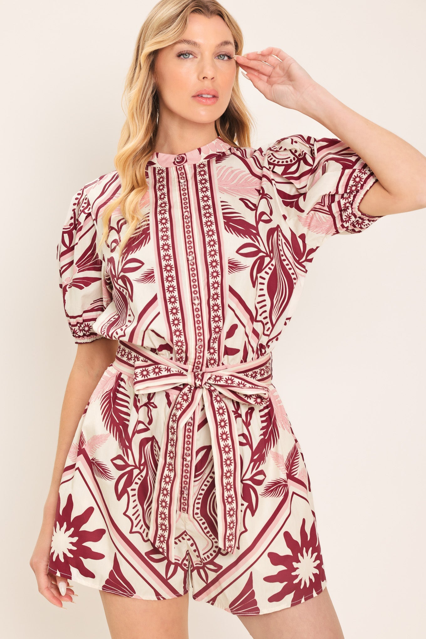 Woman wearing a burgundy patterned romper with a self tie | Flying Tomato
