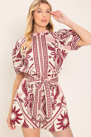 Woman wearing a burgundy patterned romper with a self tie | Flying Tomato
