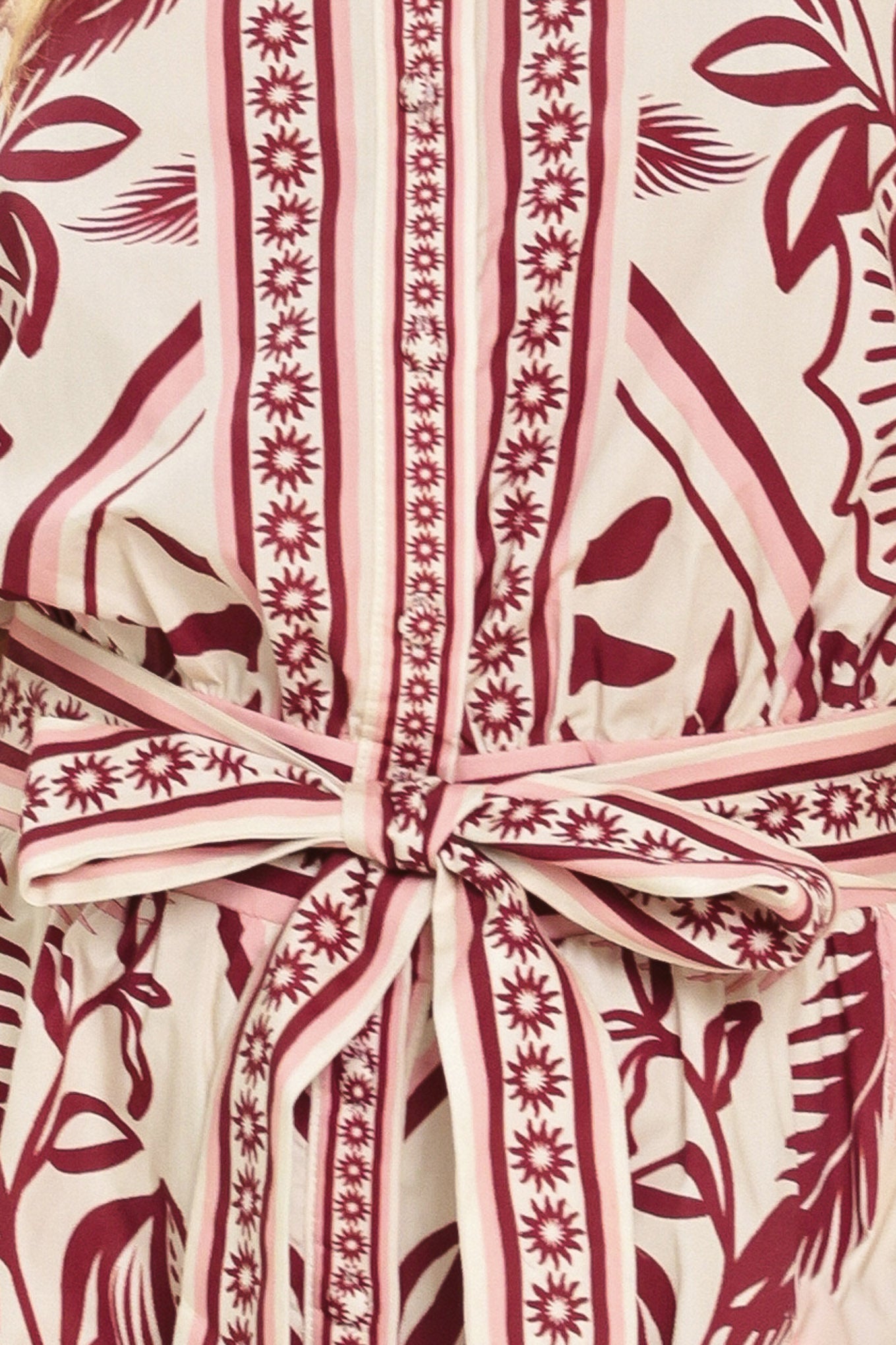 Woman wearing a burgundy patterned romper with a self tie | Flying Tomato