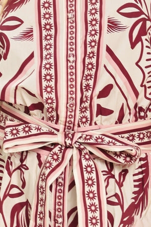 Woman wearing a burgundy patterned romper with a self tie | Flying Tomato
