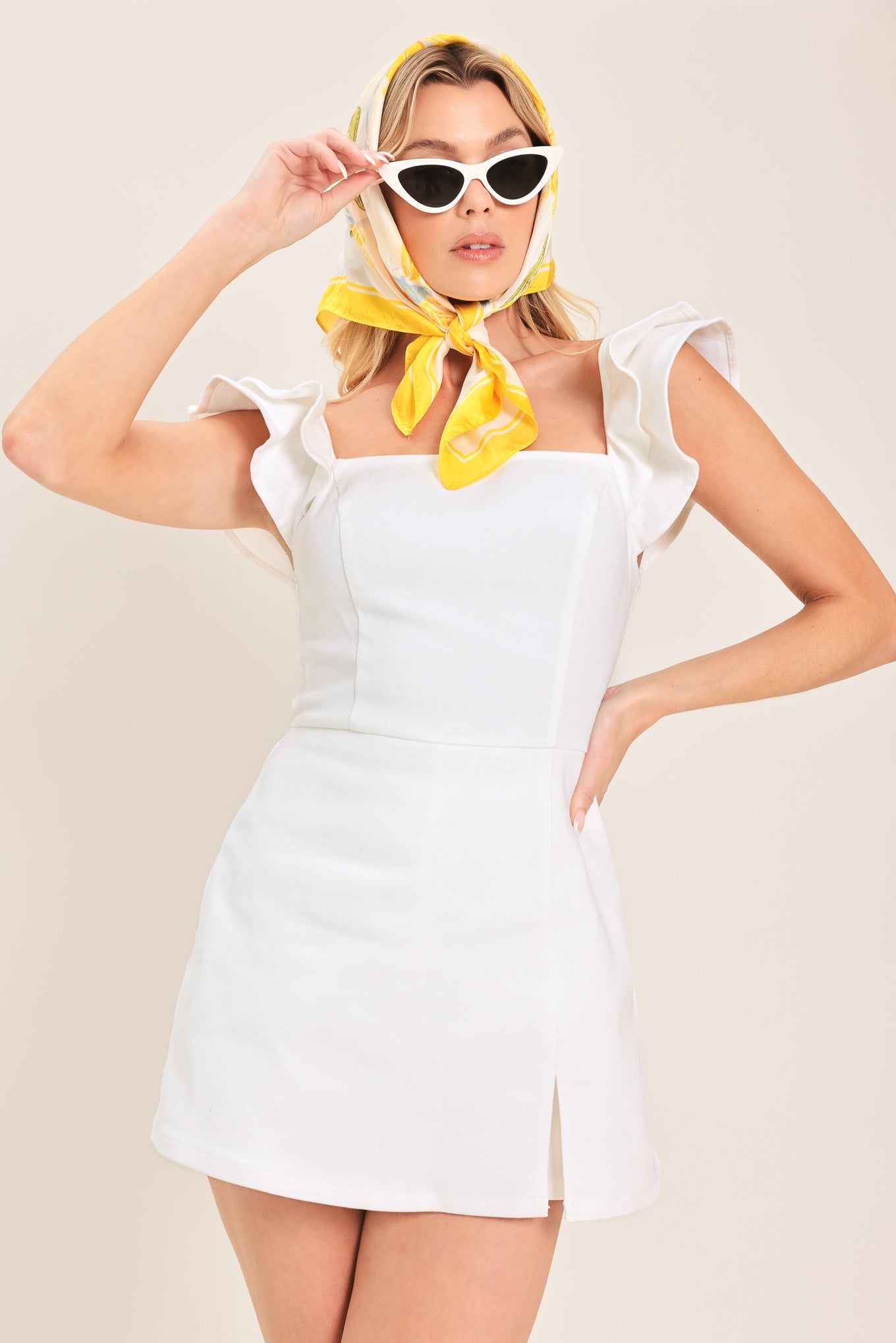 Woman wearing a white romper with square neckline, double ruffle short sleeve and back zipper | Flying Tomato