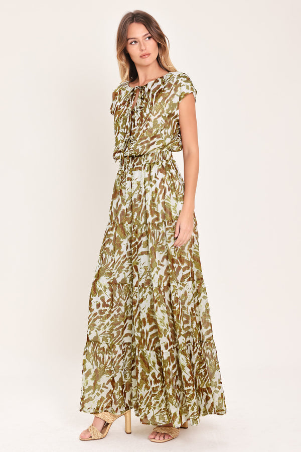 Woman wearing an olive green, brown, and white patterned woven jumpsuit featuring round neckline, short sleeve, front tie detail, elastic waist and tier wide leg pant | Flying Tomato