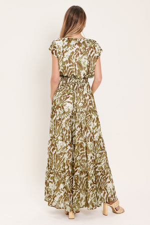 Woman wearing an olive green, brown, and white patterned woven jumpsuit featuring round neckline, short sleeve, front tie detail, elastic waist and tier wide leg pant | Flying Tomato