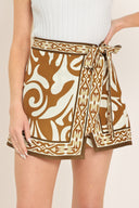 Woman wearing a brown and white patterned skort with a tie waist | Flying Tomato