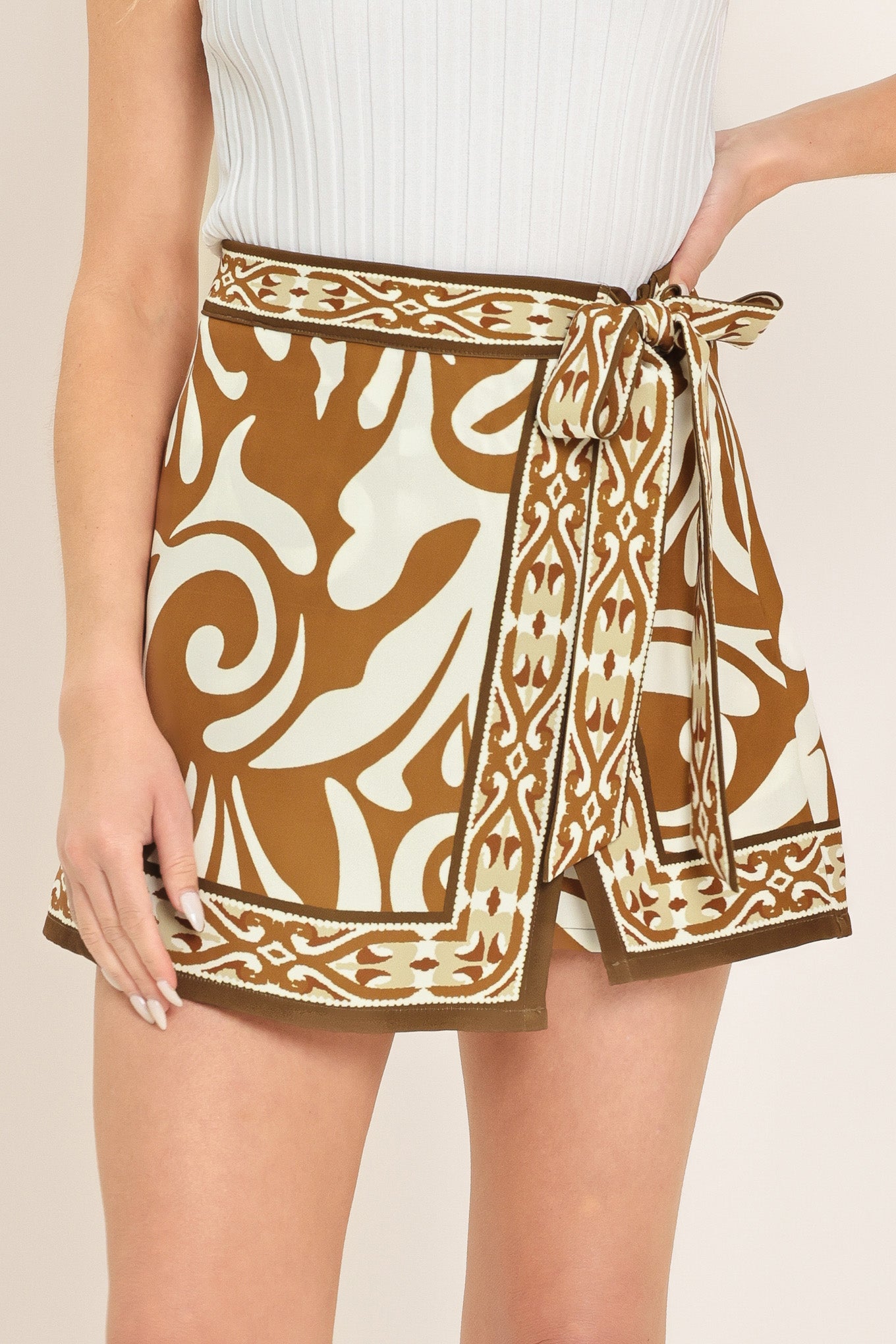 Woman wearing a brown and white patterned skort with a tie waist | Flying Tomato