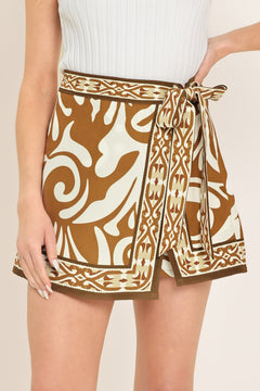 Woman wearing a brown and white patterned skort with a tie waist | Flying Tomato