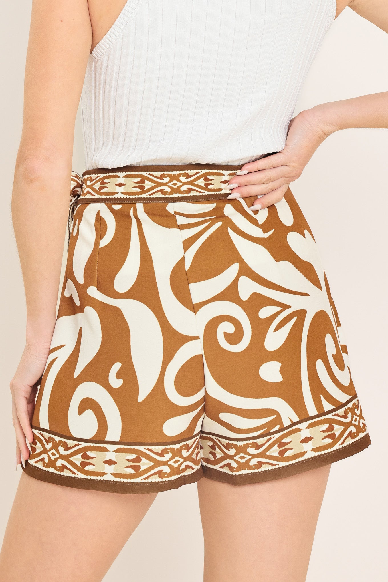 Woman wearing a brown and white patterned skort with a tie waist | Flying Tomato