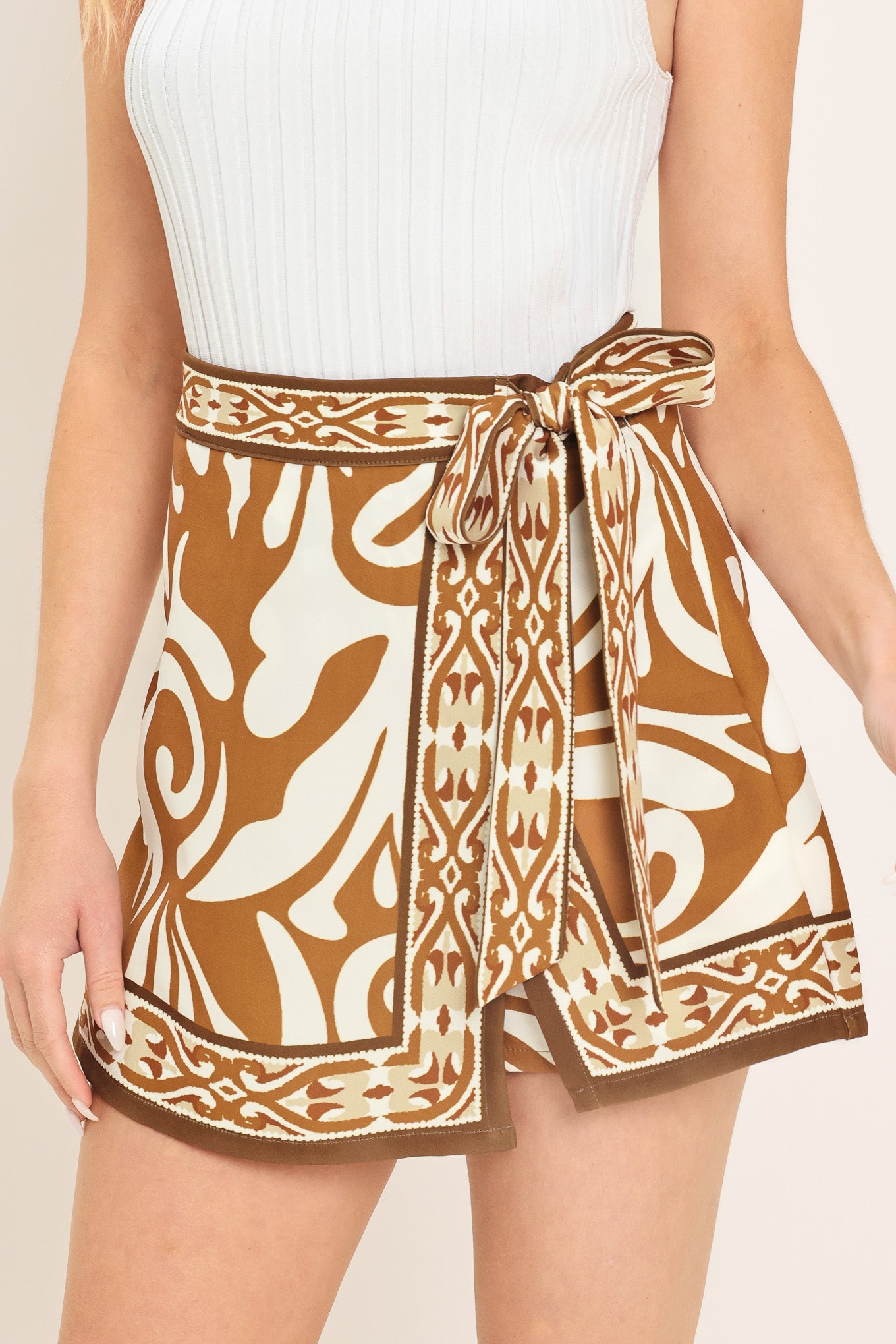 Woman wearing a brown and white patterned skort with a tie waist | Flying Tomato