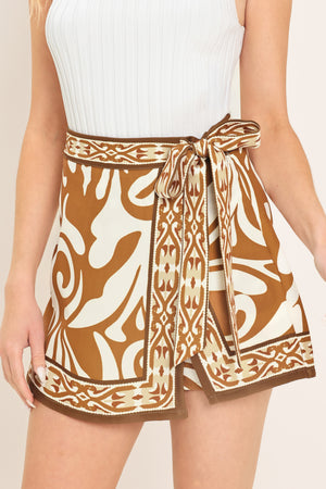 Woman wearing a brown and white patterned skort with a tie waist | Flying Tomato