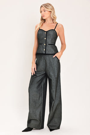 A pair of wide-leg trousers in a black denim textured fabric, shown on a model | Flying Tomato