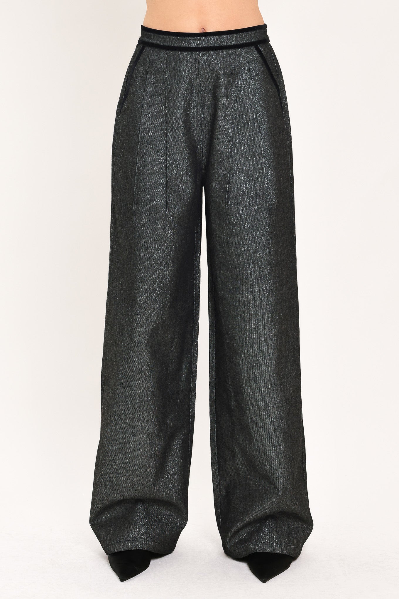 A pair of wide-leg trousers in a black denim textured fabric, shown on a model | Flying Tomato