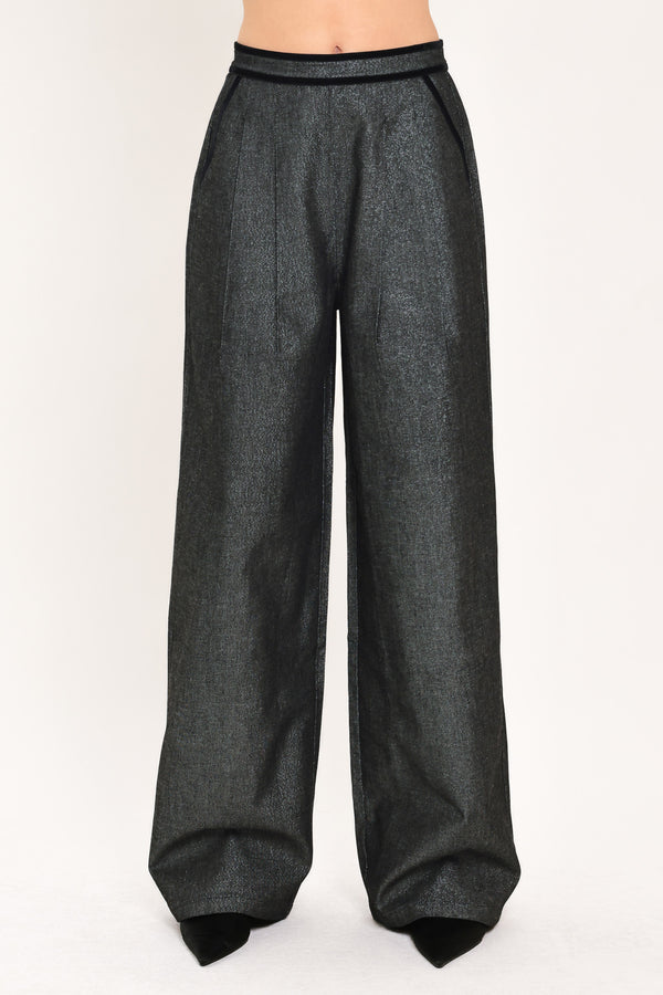 A pair of wide-leg trousers in a black denim textured fabric, shown on a model | Flying Tomato