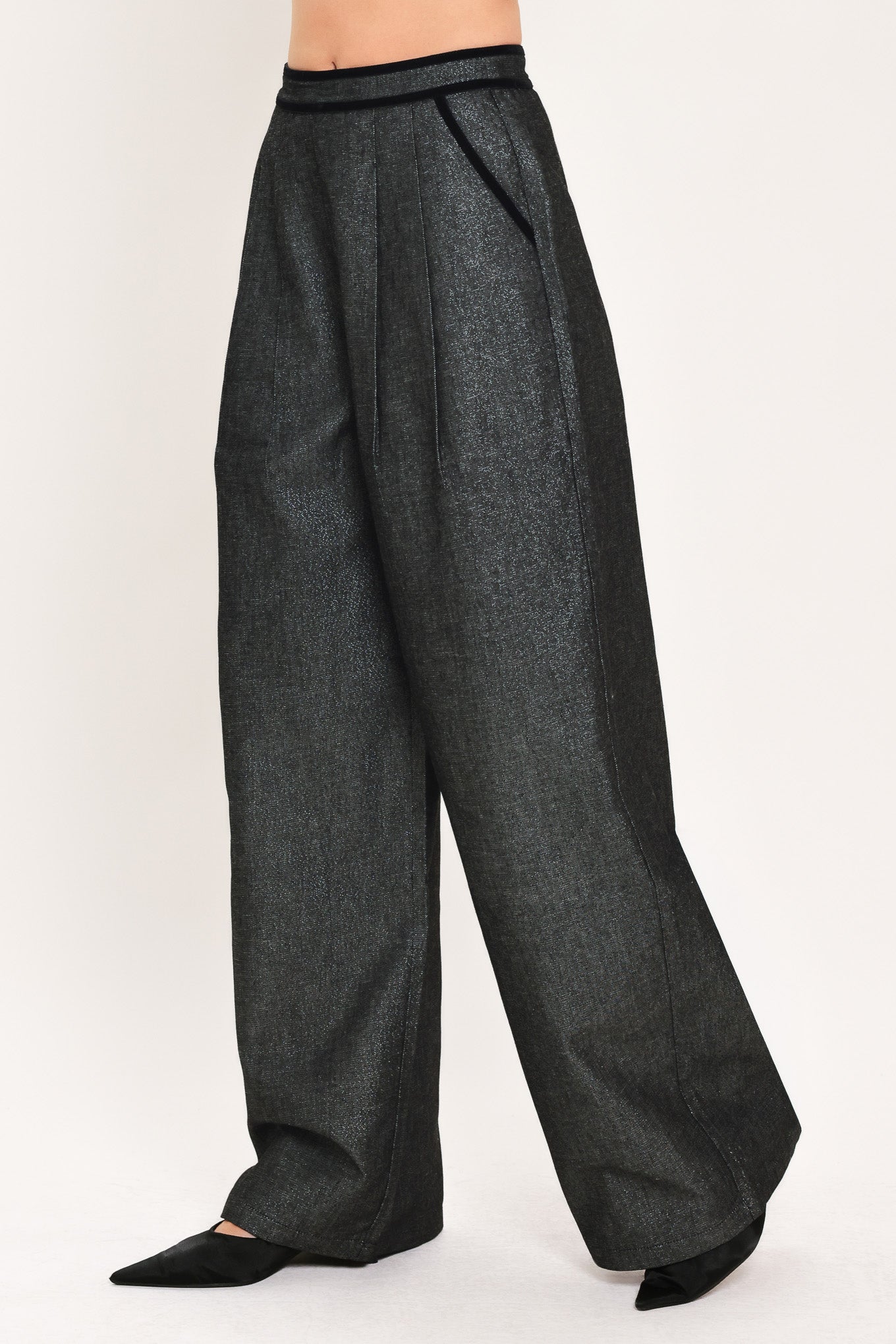A pair of wide-leg trousers in a black denim textured fabric, shown on a model | Flying Tomato