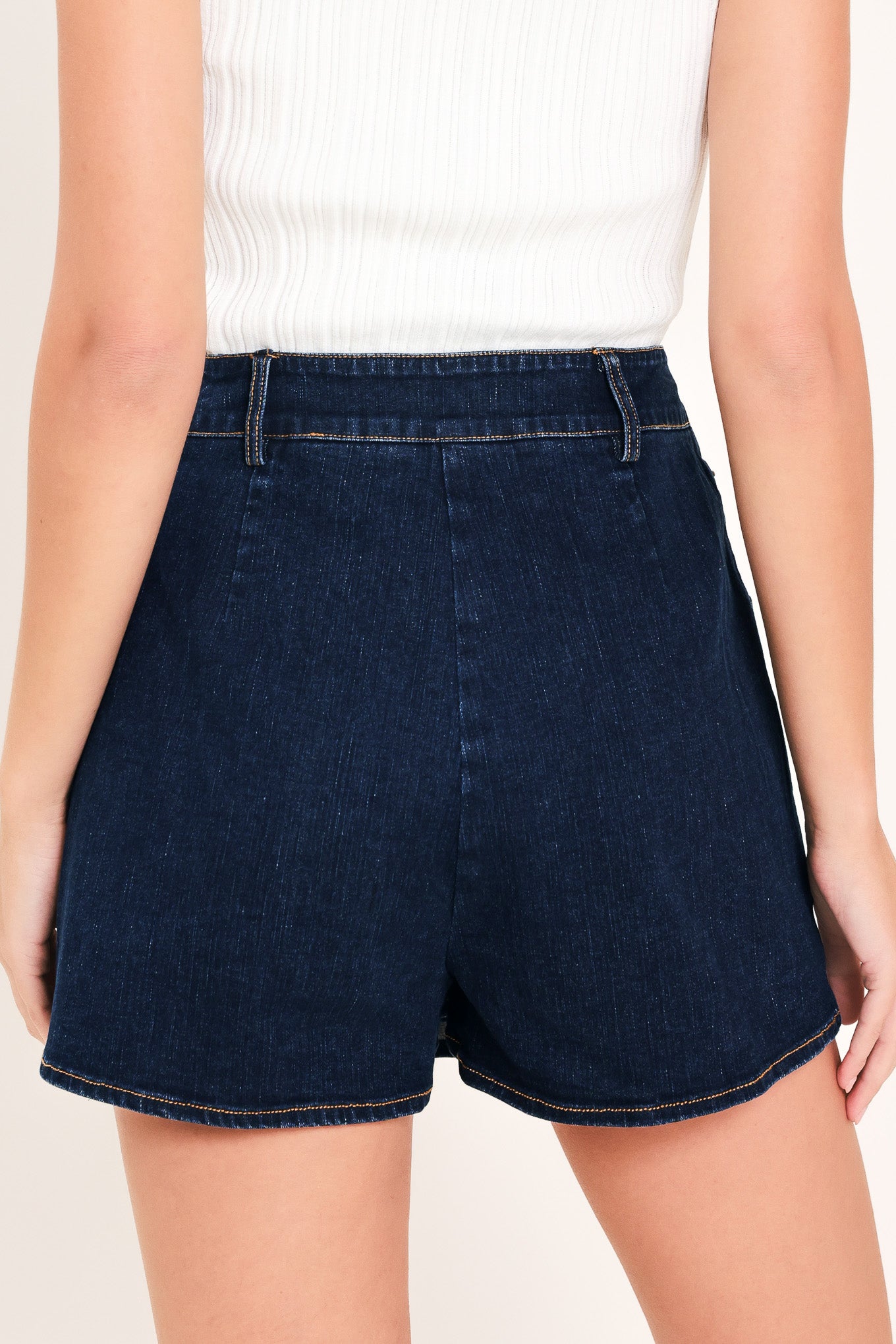 Woman wearing a dark blue denim skort with pockets | Flying Tomato